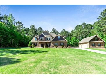 Beautiful two-story brick home with a large front lawn and mature trees at 105 Chantilly Ln, Fayetteville, GA 30215