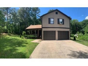Inviting two-story home featuring a two-car garage and a well-manicured lawn, perfect for curb appeal at 1500 Country Ct, Auburn, GA 30011