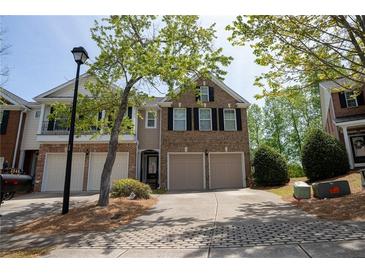 Charming two-story brick home with a two-car garage and well-maintained landscaping at 2548 Gadsen Walk, Duluth, GA 30097