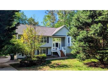 Charming home featuring mature landscaping, light-colored siding, and welcoming front porch at 510 Ward Rd, Ellenwood, GA 30294