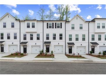 Beautiful townhomes featuring white exteriors, black accents, individual garages, and inviting curb appeal at 3170 Washburn Sw St, Atlanta, GA 30354