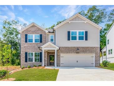 Two story home featuring a brick facade, gray siding, dark shutters, and a well-manicured lawn at 3981 Adler Cir, Buford, GA 30519