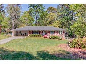 Charming one-story brick home with well-maintained lawn and a covered two car carport at 4048 Suzanne Ln, Duluth, GA 30096