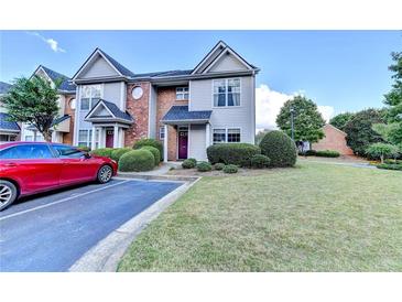 Charming townhome with well-maintained landscaping and a neat, paved parking area at 801 Old Peachtree Nw Rd # 56, Lawrenceville, GA 30043