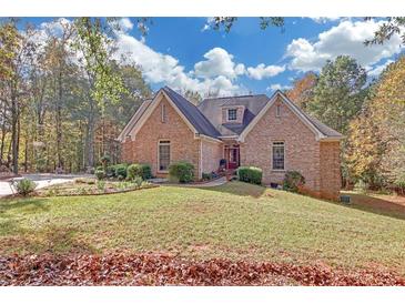 Charming brick home with manicured lawn and mature trees on a sunny day at 20 Balfour Dr, Covington, GA 30014