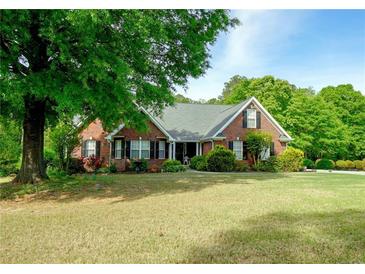 Beautiful single-story brick home with a spacious front yard and mature shade tree at 1412 Brighton Pl, Loganville, GA 30052