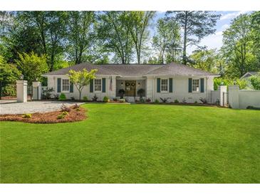 Charming, freshly painted one-story home with a large green lawn and dark blue shutters at 5641 Roberts Dr, Dunwoody, GA 30338