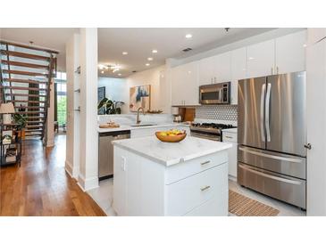 Bright kitchen features stainless steel appliances, white cabinets, marble countertops, and a stylish island at 1253 Caroline Ne St # 229, Atlanta, GA 30307