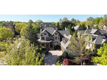 Inviting traditional home with a lush green landscape, a circular driveway, and a three-car garage at 5473 Heyward Square Pl, Marietta, GA 30068