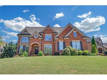 Imposing two-story brick home with manicured lawn, arched entryway, and stately curb appeal at 866 Coopers Ridge Sw Path, Grayson, GA 30017
