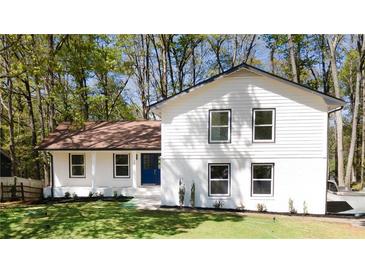 Charming two-story home featuring a manicured lawn and a striking blue front door at 185 Ansley Ct, Roswell, GA 30076