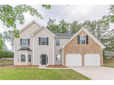 Inviting two-story home with a brick-accented two-car garage, complemented by a well-manicured lawn at 4500 Nocohoma Bnd, Douglasville, GA 30135