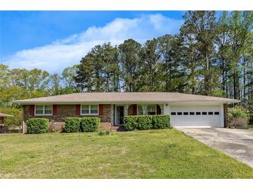 Charming brick home with a well-manicured front yard and a two-car garage at 4164 Weston Dr, Powder Springs, GA 30127