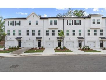 New townhomes with white siding, black trim, garage doors and landscaping at 148 Werner Brook Sw Way, Atlanta, GA 30354