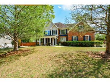 Charming two-story home with a large front yard, mature trees and a welcoming entrance at 3239 Rose Petal Ln, Powder Springs, GA 30127