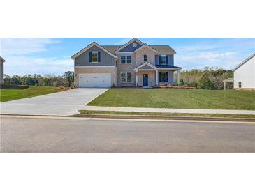Inviting two-story home with a manicured lawn, brick and gray siding, and a spacious two-car garage at 123 Felicity Pike, Locust Grove, GA 30248