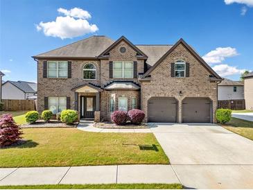 Charming two-story brick home with a well-manicured lawn, two-car garage, and inviting curb appeal at 4689 Shire Dr, Lithonia, GA 30038