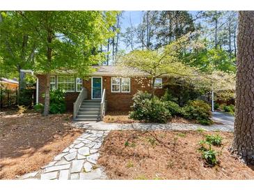 Charming brick home with a stone walkway and mature trees creating a welcoming curb appeal at 404 Bridlewood Cir, Decatur, GA 30030