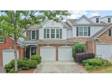 Charming townhome boasts a two-car garage, well-manicured landscaping, and a classic facade with neutral tones at 1491 Bellsmith Dr, Alpharetta, GA 30076