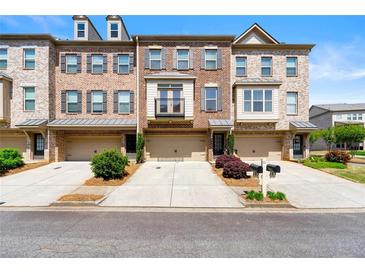 Charming brick townhome featuring attached garages and well-manicured landscaping, offering a welcoming curb appeal at 282 Autry Mill Ln, Suwanee, GA 30024