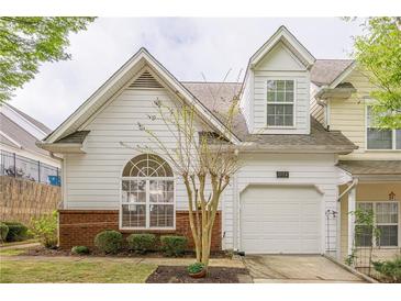 Charming home featuring a one-car garage, lovely landscaping, and large arched window offering natural light at 1052 Pike Forest Ct, Lawrenceville, GA 30045