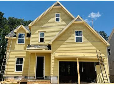 Charming yellow two-story home with a welcoming front door and attached two-car garage at 3350 Hillshire Dr, Cumming, GA 30028