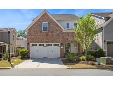 Charming two-story brick home with a two-car garage and well-manicured landscaping on a sunny day at 518 Coral St, Marietta, GA 30064
