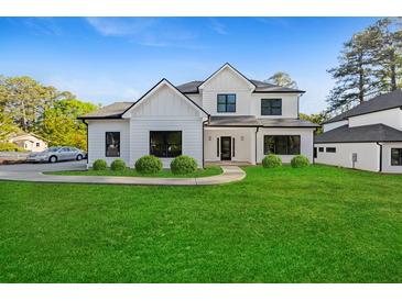 Modern two-story home with white siding, black windows, and a well-manicured lawn at 2059 Mozelle Dr, Marietta, GA 30062