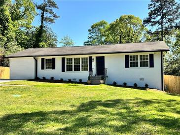 Charming single-story home with manicured lawn and a classic white exterior with black shutters at 6751 Davidson Ct, Lithonia, GA 30058