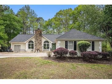 Charming single-story home featuring a stone chimney and well-maintained landscaping at 110 Emerald Dr, Mcdonough, GA 30253
