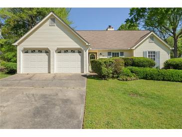 Charming ranch-style home with a two-car garage and well-manicured front lawn at 1220 Paddocks Way, Powder Springs, GA 30127