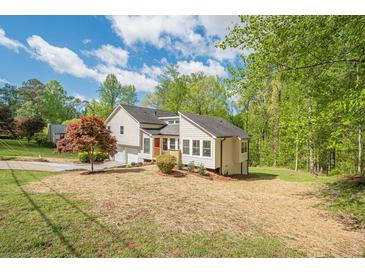 Charming two-story home with a manicured lawn, and a welcoming red front door at 128 Partridge Rdg, Woodstock, GA 30188
