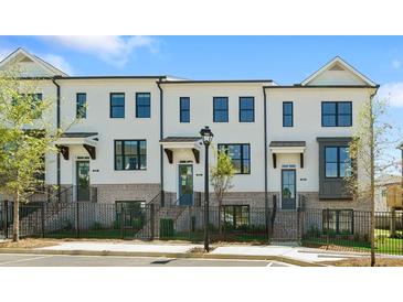 Modern townhome featuring a brick and white facade, black-framed windows, and individual entrances at 2852 Evanshire Ave # 114, Duluth, GA 30096