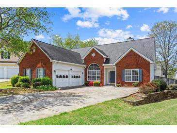 Charming brick home featuring an attached two-car garage, well-manicured lawn, and inviting curb appeal at 1284 Charter Club Ct, Lawrenceville, GA 30043