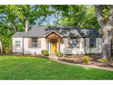 Charming home with a yellow door, shutters, and mature trees in a lush yard at 1611 Belmont Sw Ave, Atlanta, GA 30310