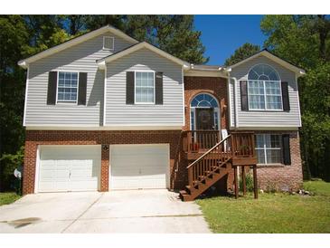 Charming two-story home featuring a brick and siding exterior, attached garage, and landscaped front yard at 2176 Cold Springs Cir, Lithonia, GA 30058