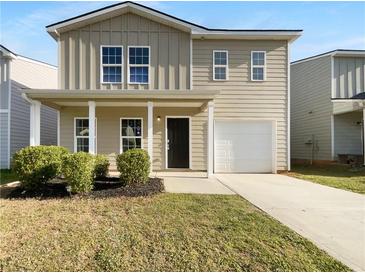 Charming two-story home with a covered front porch, one-car garage, and well-maintained landscaping at 325 Freeman Cir, Villa Rica, GA 30180