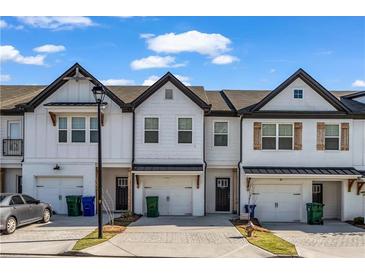 Charming townhome with white siding, black trim, and a one-car garage, creating an inviting curb appeal at 4142 Spring Valley Cir # 65, Tucker, GA 30084