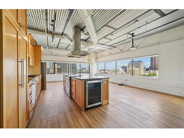 Bright kitchen with wooden cabinets, island, and stainless steel appliances overlooking the city skyline at 120 Ralph Mcgill Ne Blvd # 1304 & 1305, Atlanta, GA 30308