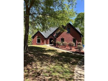Charming brick home featuring manicured landscaping and a well-maintained front yard at 225 Austin Oaks Se Dr, Ellenwood, GA 30294