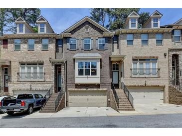 Charming brick townhome featuring a two-car garage, well-maintained landscaping, and inviting front entrances at 1372 Doublegate Dr, Atlanta, GA 30319