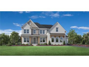 Charming two-story home featuring a mix of brick and stone accents, a dark roof and a beautifully landscaped front yard at 4995 Travers Ln, Cumming, GA 30040