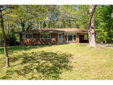 Charming brick ranch-style home with a well-manicured lawn and mature trees at 1650 Randee Nw St, Atlanta, GA 30318