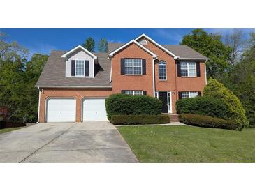 Charming two-story brick home with a well-maintained lawn and a two-car garage at 2432 Pendergrass Ln, Ellenwood, GA 30294