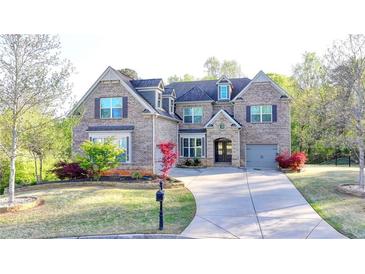 Charming brick home with a well-manicured lawn and a curved driveway at 4155 Winterberry Rd, Cumming, GA 30040