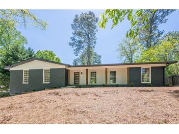 Charming single-story home with painted brick, modern door, and manicured front yard at 3350 Pine Meadow Nw Rd, Atlanta, GA 30327