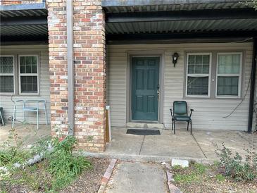 Cozy front porch featuring neutral siding and a green front door and two windows at 3071 Colonial Way # K, Atlanta, GA 30341