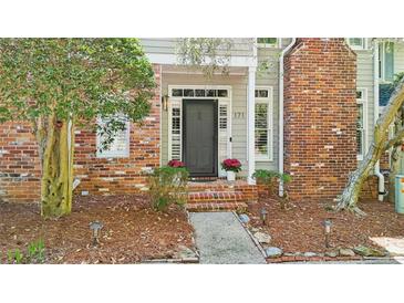 Charming brick home featuring a beautiful front door, manicured landscaping, and inviting entrance at 171 Riverview Trl, Roswell, GA 30075