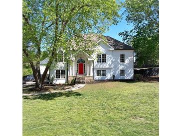 Charming two-story home with a bright red front door, complemented by a lush green lawn and mature trees at 1770 Bethany Spring, Cumming, GA 30041