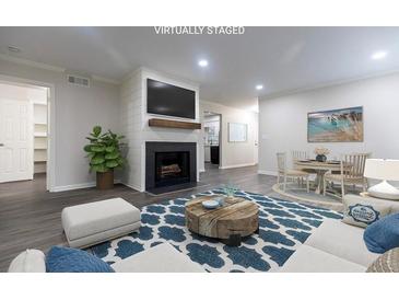 Cozy living room features a modern fireplace, wood floors, and open floor plan at 600 Bedfort Dr, Duluth, GA 30096